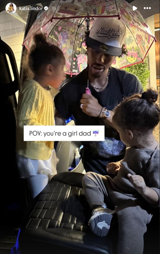 Lindor helping his daughters settle in the back seat of the car