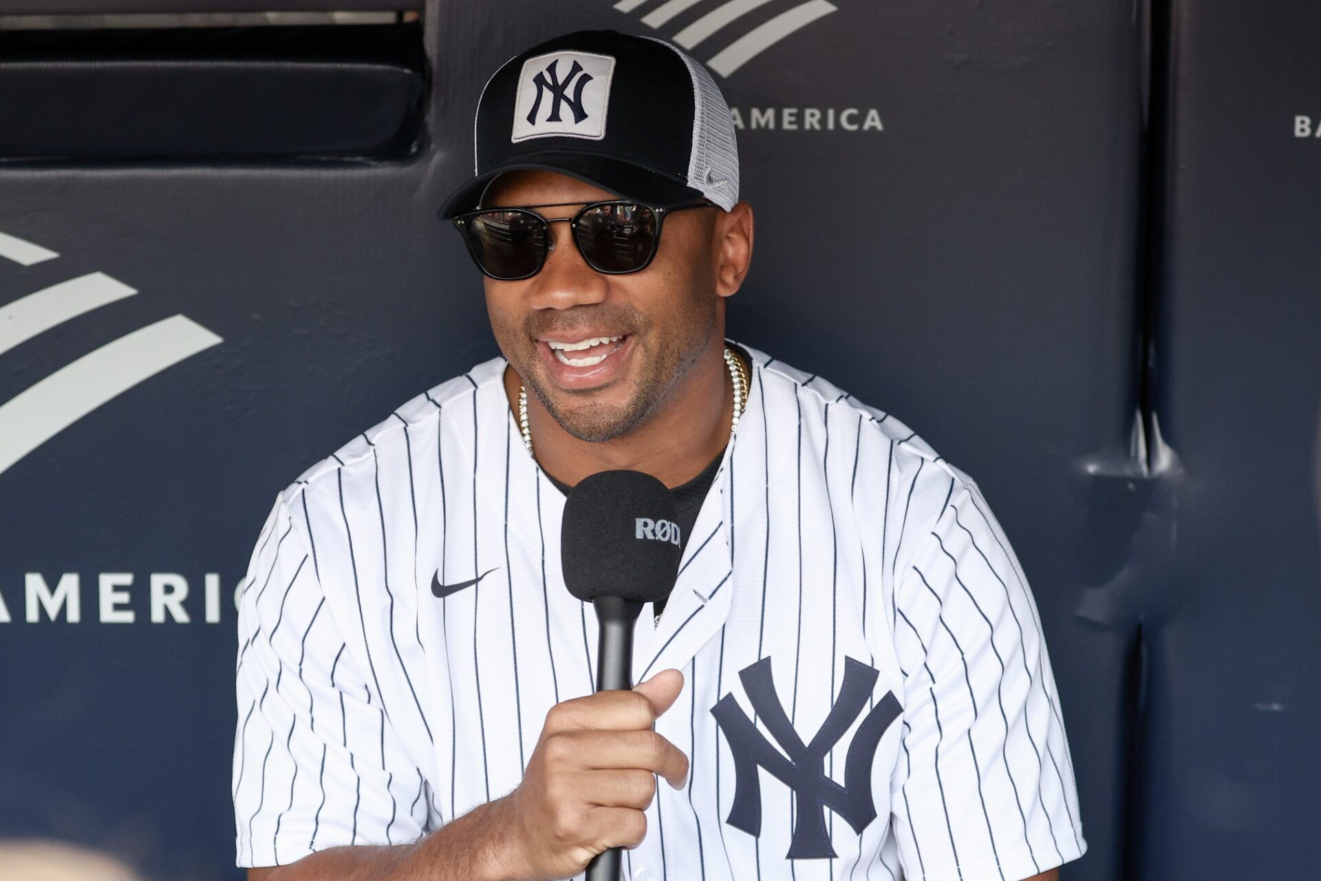 New York Giants quarterback Russell Wilson is interviewed prior to the game between the New York Mets and the New York Yankees at Yankee Stadium.