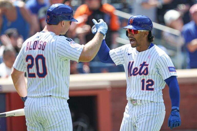 New York Mets shortstop Francisco Lindor (12) celebrates with first baseman Pete Alonso (20) after hitting a solo home run during the eighth inning against the Chicago Cubs at Citi Field.