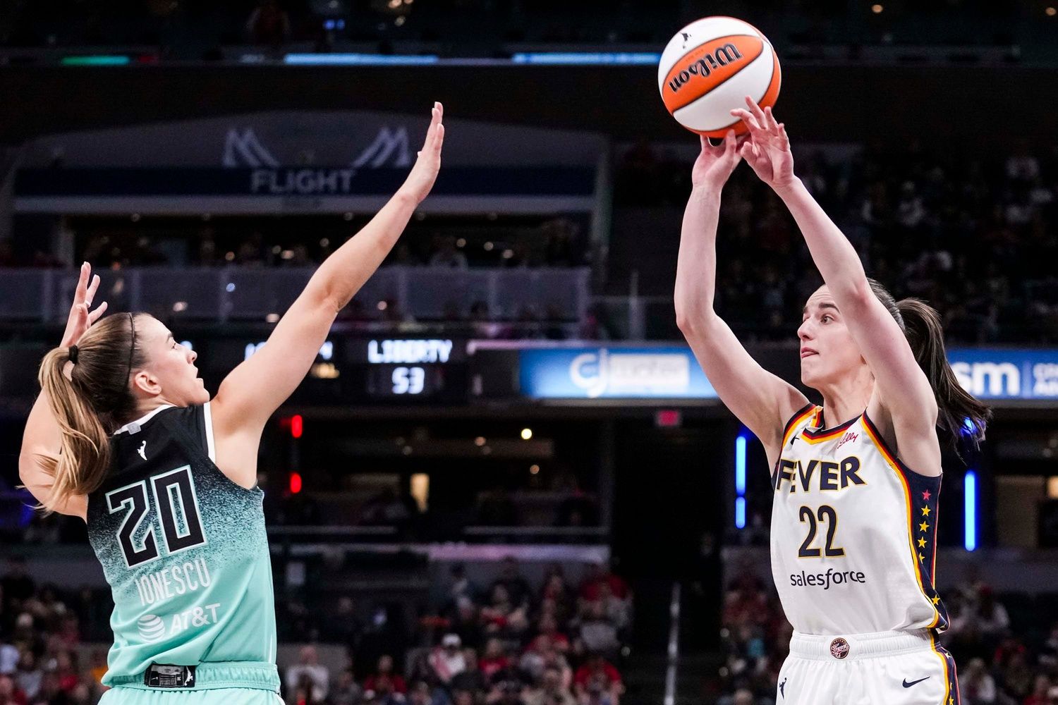 Indiana Fever guard Caitlin Clark (22) attempts a 3-pointer against New York Liberty guard Sabrina Ionescu (20) on Saturday, May 24, 2025, during a game between the Indiana Fever and the New York Liberty at Gainbridge Fieldhouse in Indianapolis.