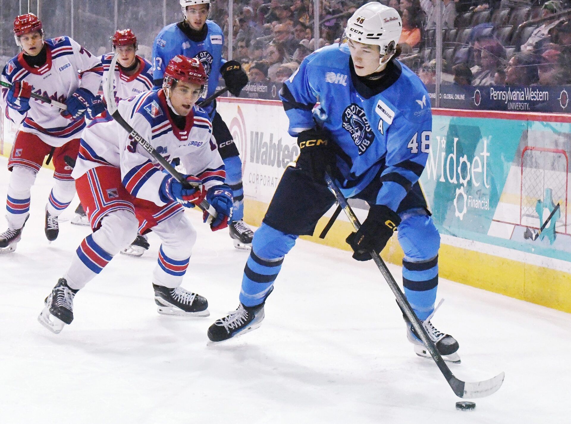 Erie Otters defenseman Matthew Schaefer, right, controls the puck against the Kitchener Rangers at Erie Insurance Arena in Erie on Nov. 23, 2024.