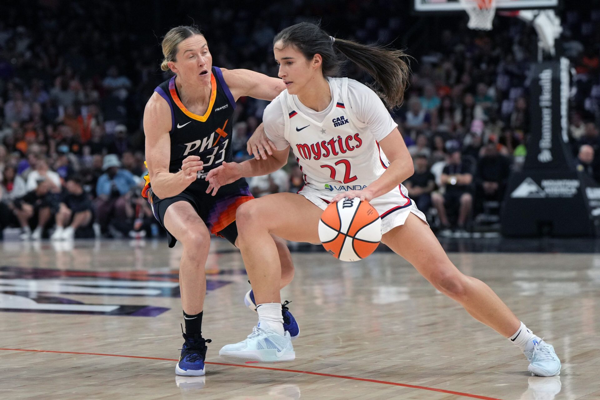 Washington Mystics guard Sonia Citron (22) drives on Phoenix Mercury guard Sami Whitcomb (33) in the first half at Footprint Center.