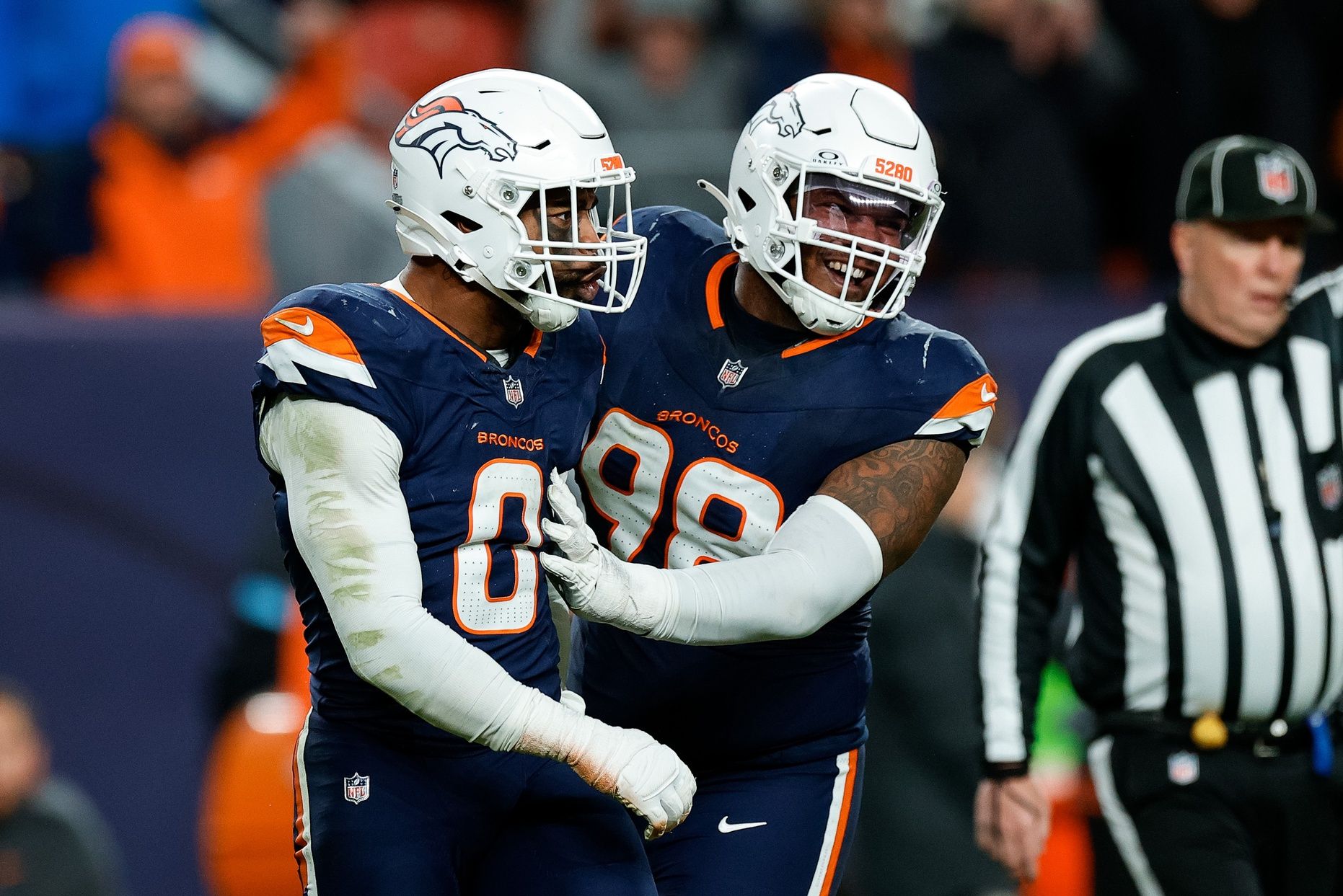 Denver Broncos linebacker Jonathon Cooper (0) reacts with defensive end John Franklin-Myers (98) after a play in the fourth quarter against the Cleveland Browns at Empower Field at Mile High.