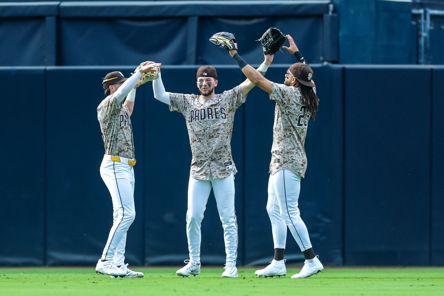 San Diego Padres left fielder Tyler Wade (14), center fielder Jackson Merrill (3) and right fielder Fernando Tatis Jr. (23) celebrate after defeating the Pittsburgh Pirates at Petco Park.