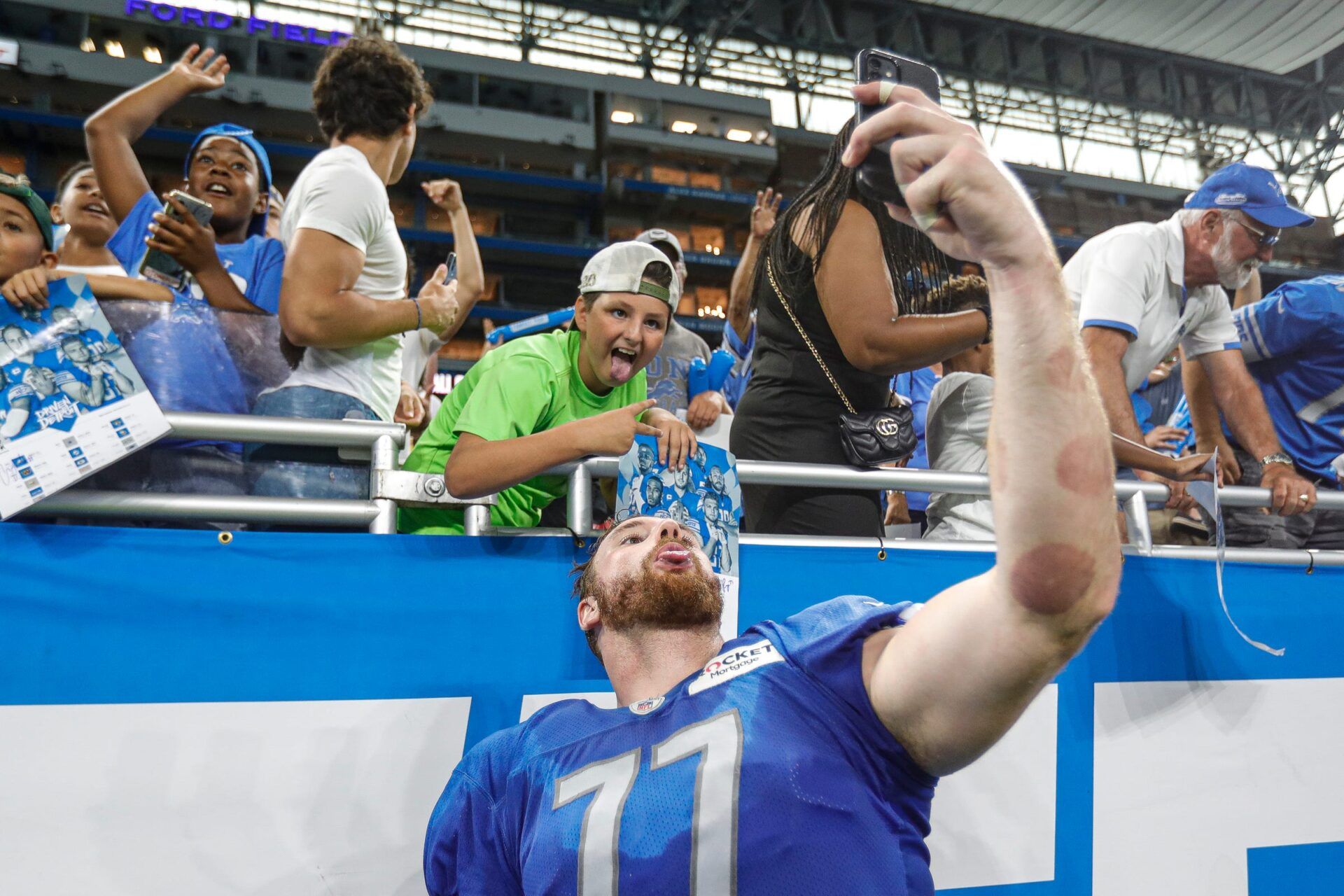 Detroit Lions offensive line Frank Ragnow (77) takes a selfie with fans after open practice at Family Fest at Ford Field in Detroit on Saturday, August 6, 2022.