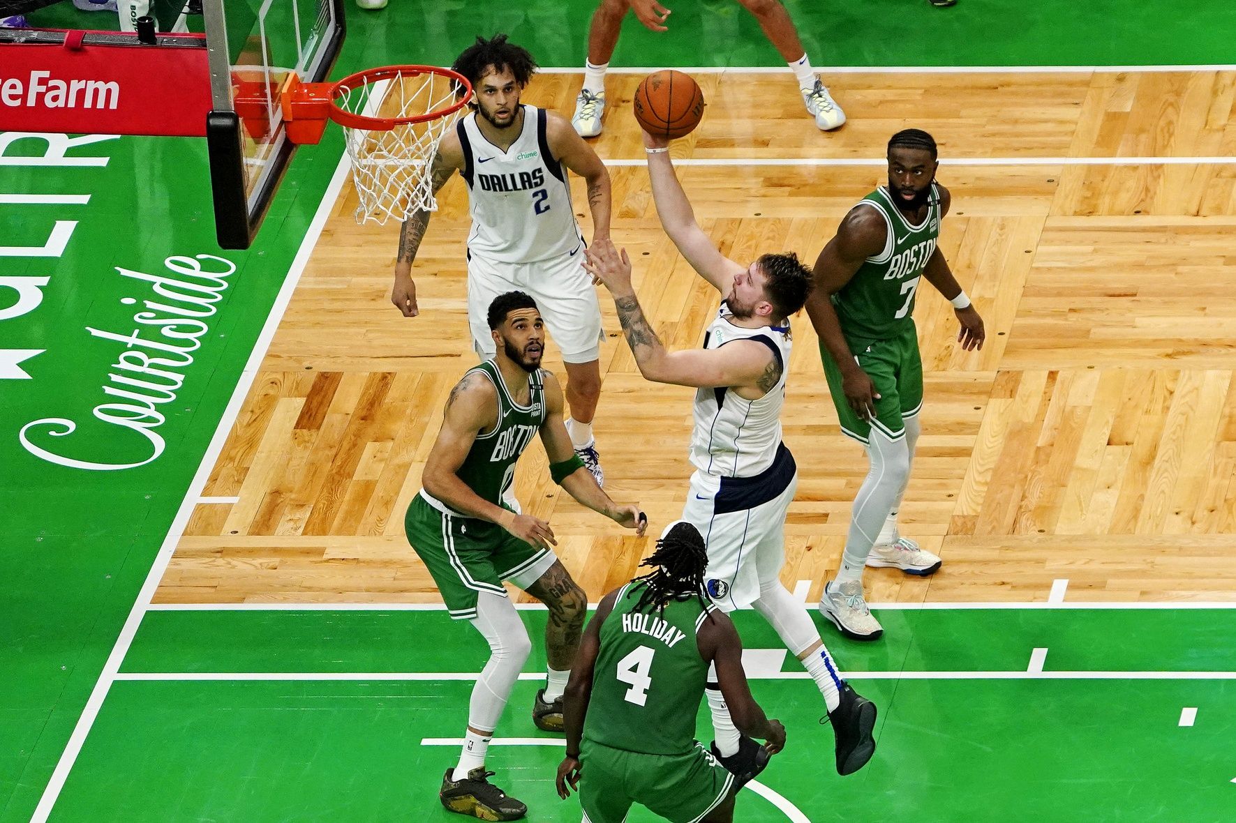 Dallas Mavericks guard Luka Doncic (77) shoots the ball against Boston Celtics forward Jayson Tatum (0) in game five of the 2024 NBA Finals at TD Garden.
