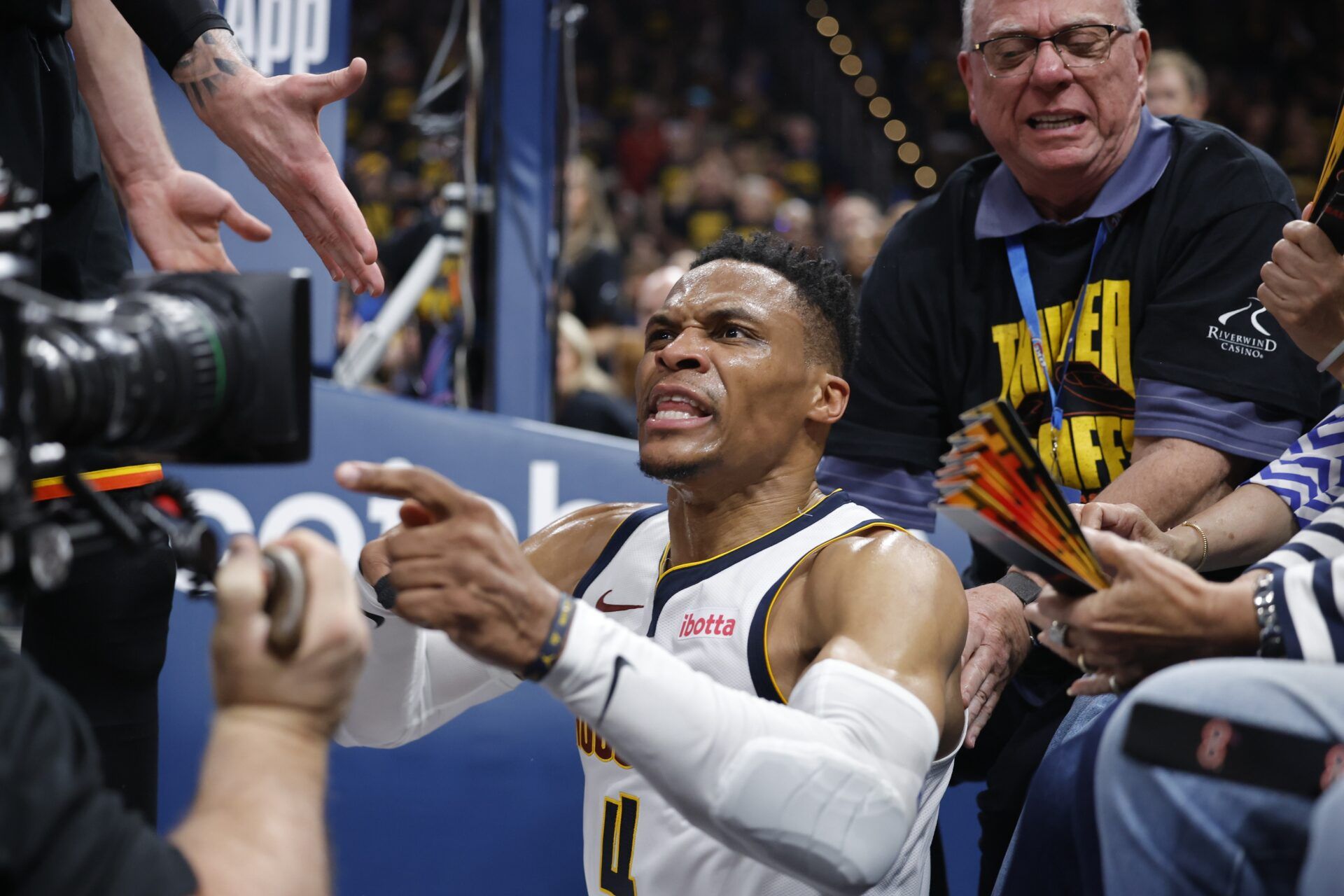 Denver Nuggets guard Russell Westbrook (4) reacts after a play and falling into fans in the second quarter against the Oklahoma City Thunder during game two of the second round for the 2025 NBA Playoffs at Paycom Center.