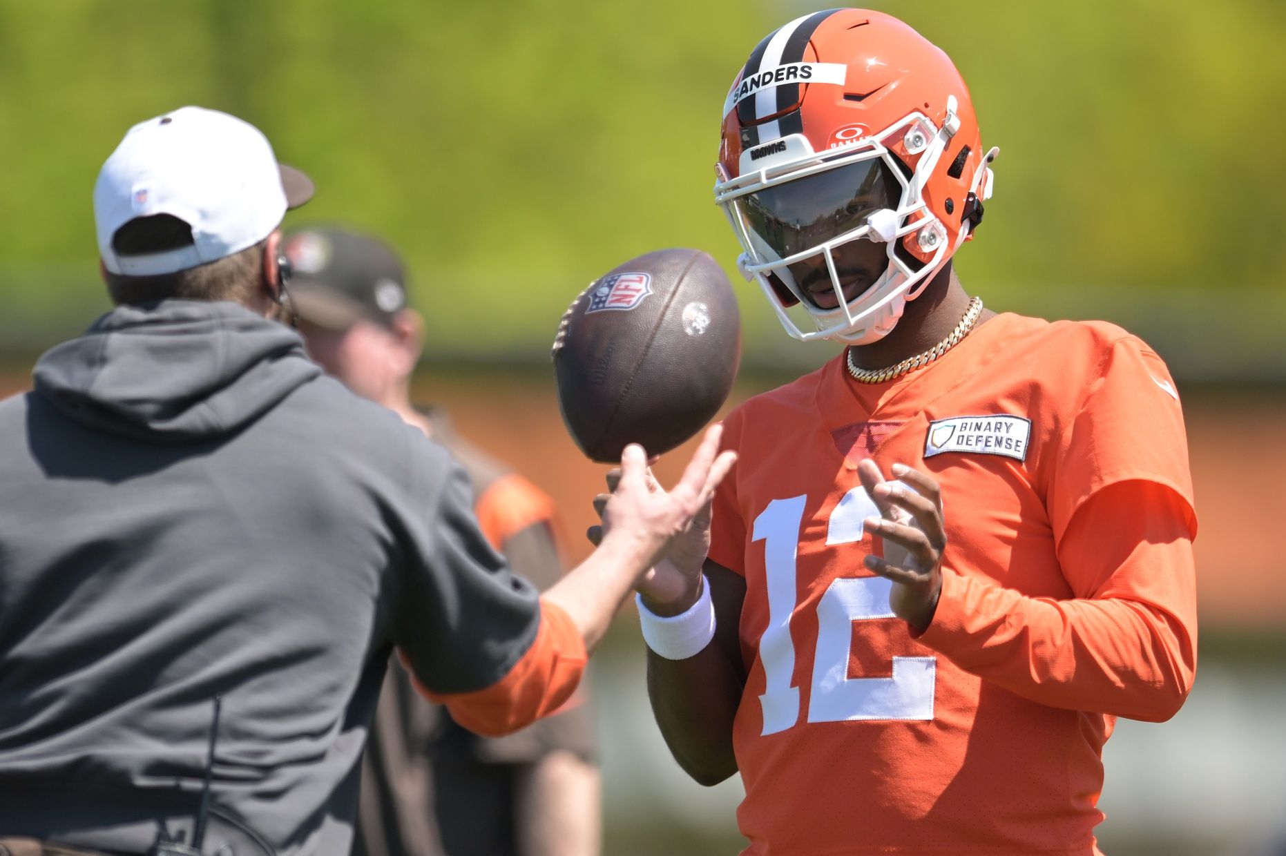 Cleveland Browns quarterback Shedeur Sanders (12) talks to a coach during rookie minicamp at CrossCountry Mortgage Campus.