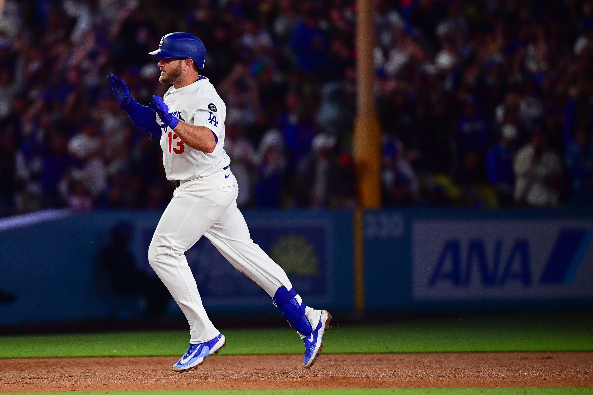 Los Angeles Dodgers third baseman Max Muncy (13) runs the bases after hitting a solo home run against the New York Mets during the ninth inning at Dodger Stadium.