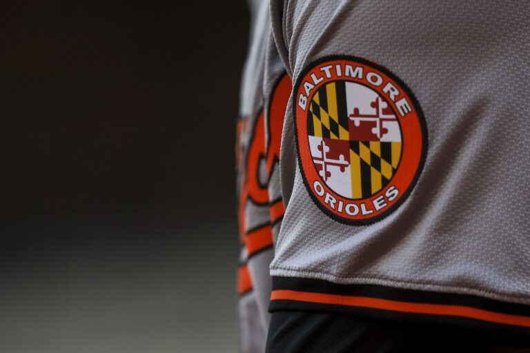The Baltimore Orioles logo on the sleeve of designated hitter Gunnar Henderson (2) as he prepares on deck during the seventh inning against the Cincinnati Reds at Great American Ball Park.