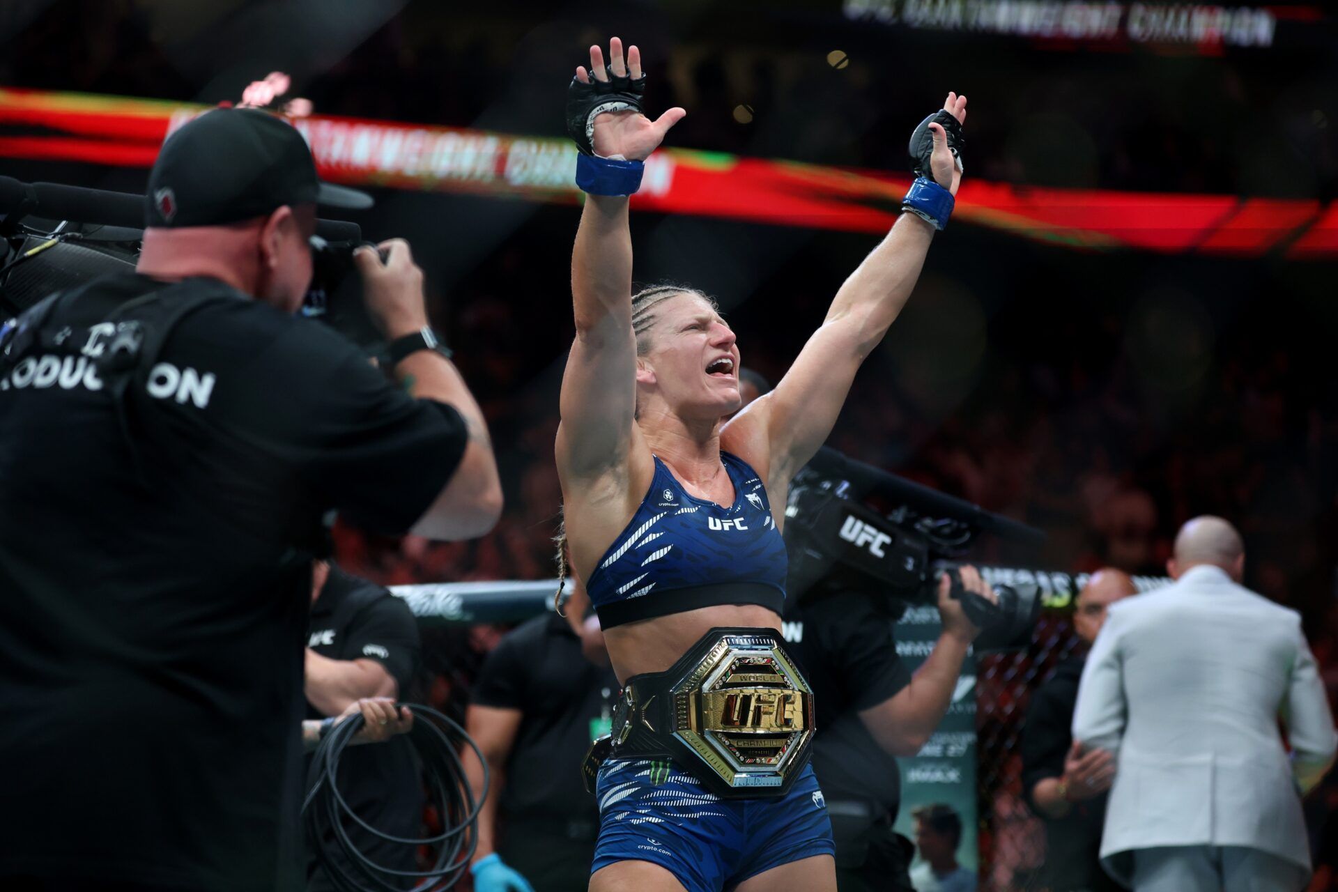 Kayla Harrison (blue gloves) reacts after defeating Julianna Pena (not pictured) in a bantamweight title bout during UFC 316 at Prudential Center.