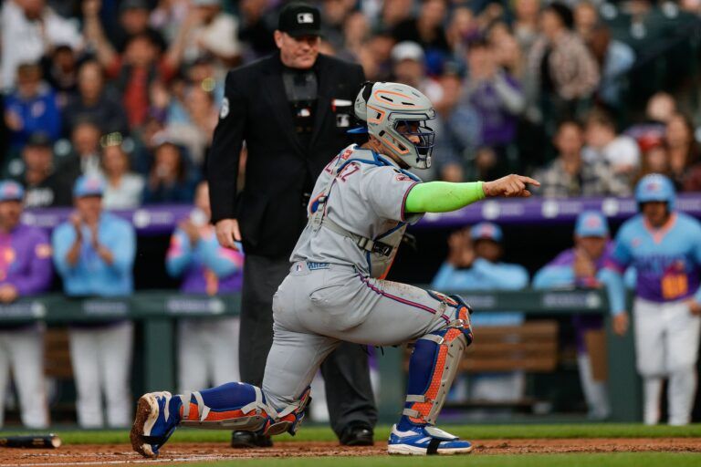 New York Mets catcher Francisco Alvarez (4) gestures to the dugout to challenge a call on the field in the fifth inning against the Colorado Rockies at Coors Field.