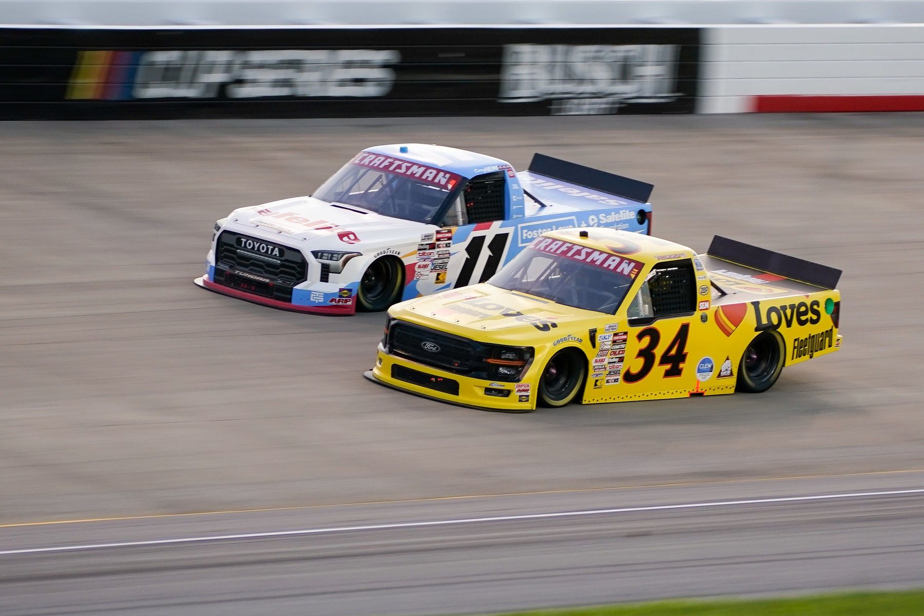 NASCAR Truck Series driver Corey Heim (11) and Layne Riggs (34) race during the Rackley Roofing 200 at Nashville Superspeedway in Lebanon, Tenn., Friday, May 30, 2025.