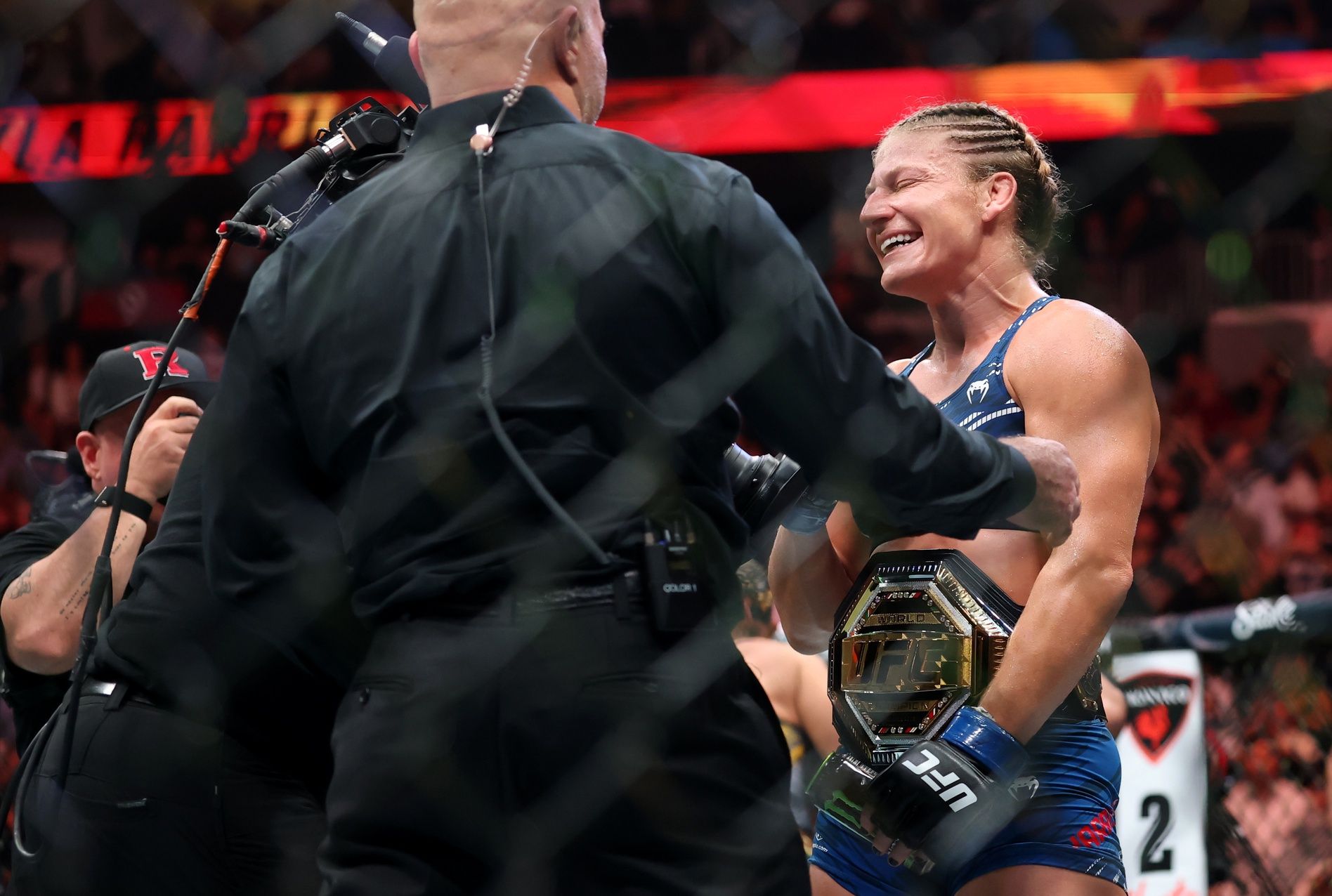 Kayla Harrison (blue gloves) reacts after defeating Julianna Pena (not pictured) in a bantamweight title bout during UFC 316 at Prudential Center.