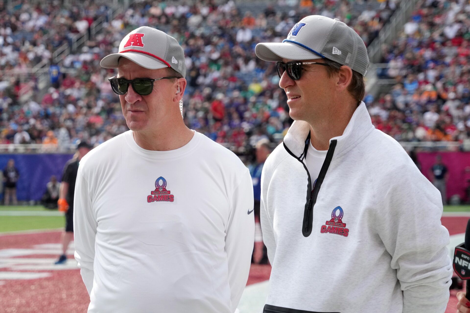 AFC coach Peyton Manning (left) and brother and NFC coach Eli Manning watch during the 2025 Pro Bowl Games at Camping World Stadium.