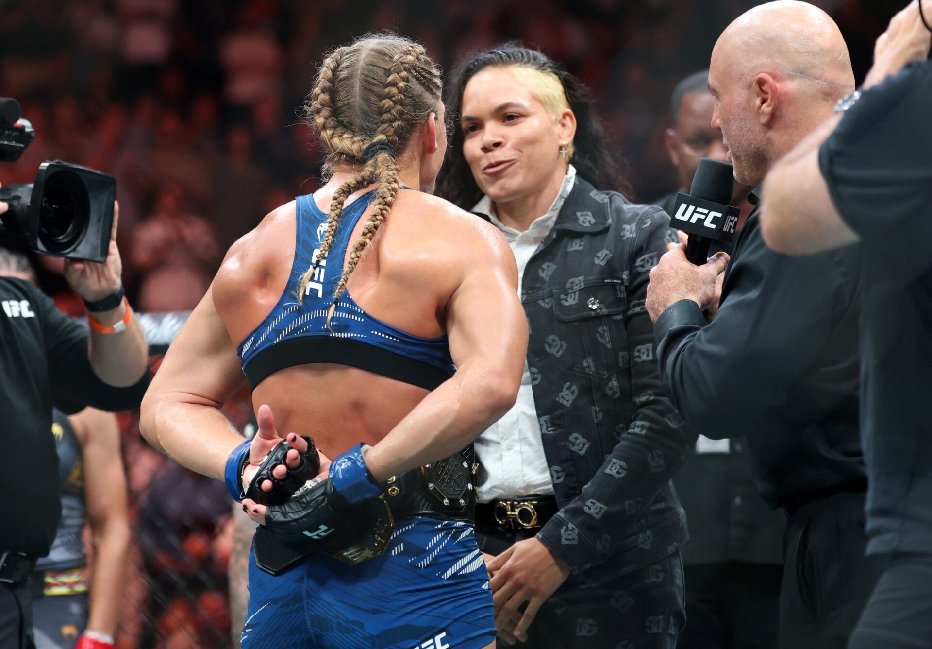 Kayla Harrison (blue gloves) talks to Amanda Nunes after defeating Julianna Pena (not pictured) in a bantamweight title bout during UFC 316 at Prudential Center.