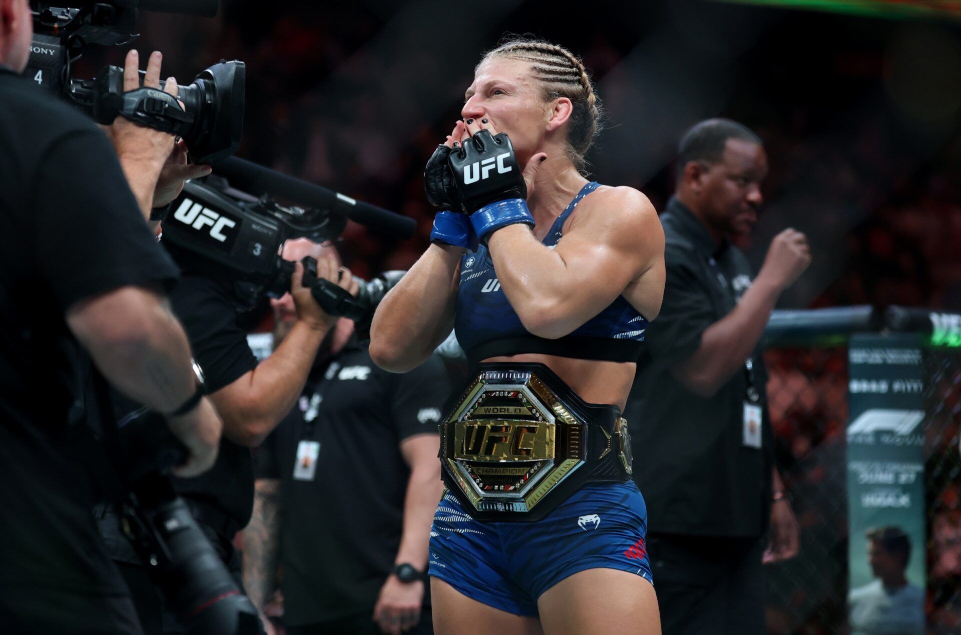 Kayla Harrison (blue gloves) reacts after defeating Julianna Pena (not pictured) in a bantamweight title bout during UFC 316 at Prudential Center.