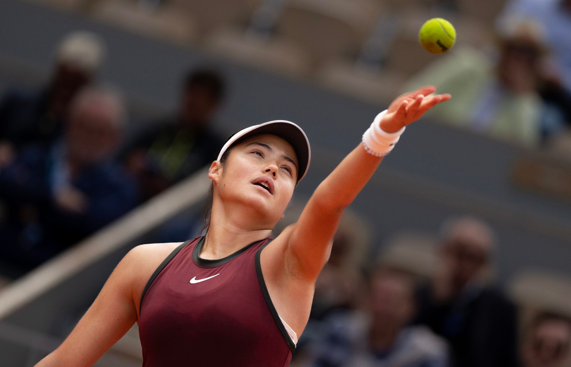 Emma Raducanu of Great Britain tosses the ball to serve during her match against Iga Swiatek of Poland on day four at Roland Garros Stadium.
