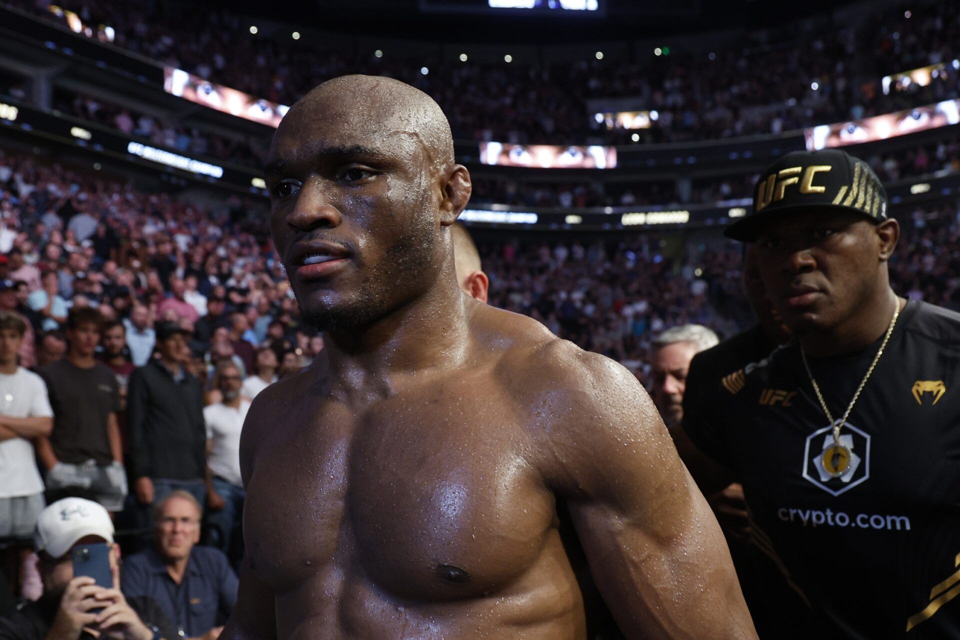 Kamaru Usman (red gloves) leaves the arena after being defeated by Leon Edwards (blue gloves) during UFC 278 at Vivint Arena.