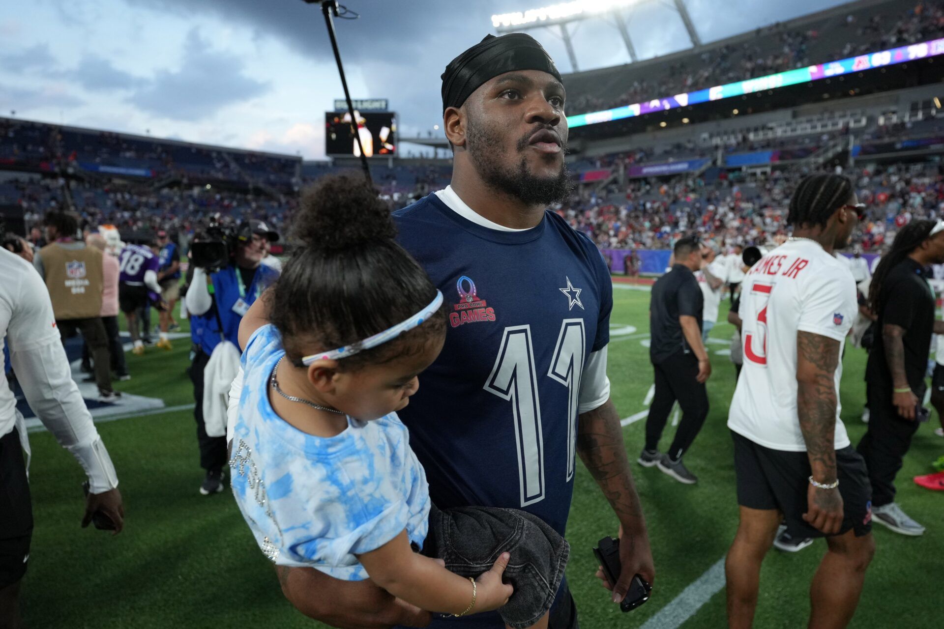 NFC defensive end Micah Parson of the Dallas Cowboys (11) holds his daughter Shatara Parsons after the 2025 Pro Bowl Games at Camping World Stadium.