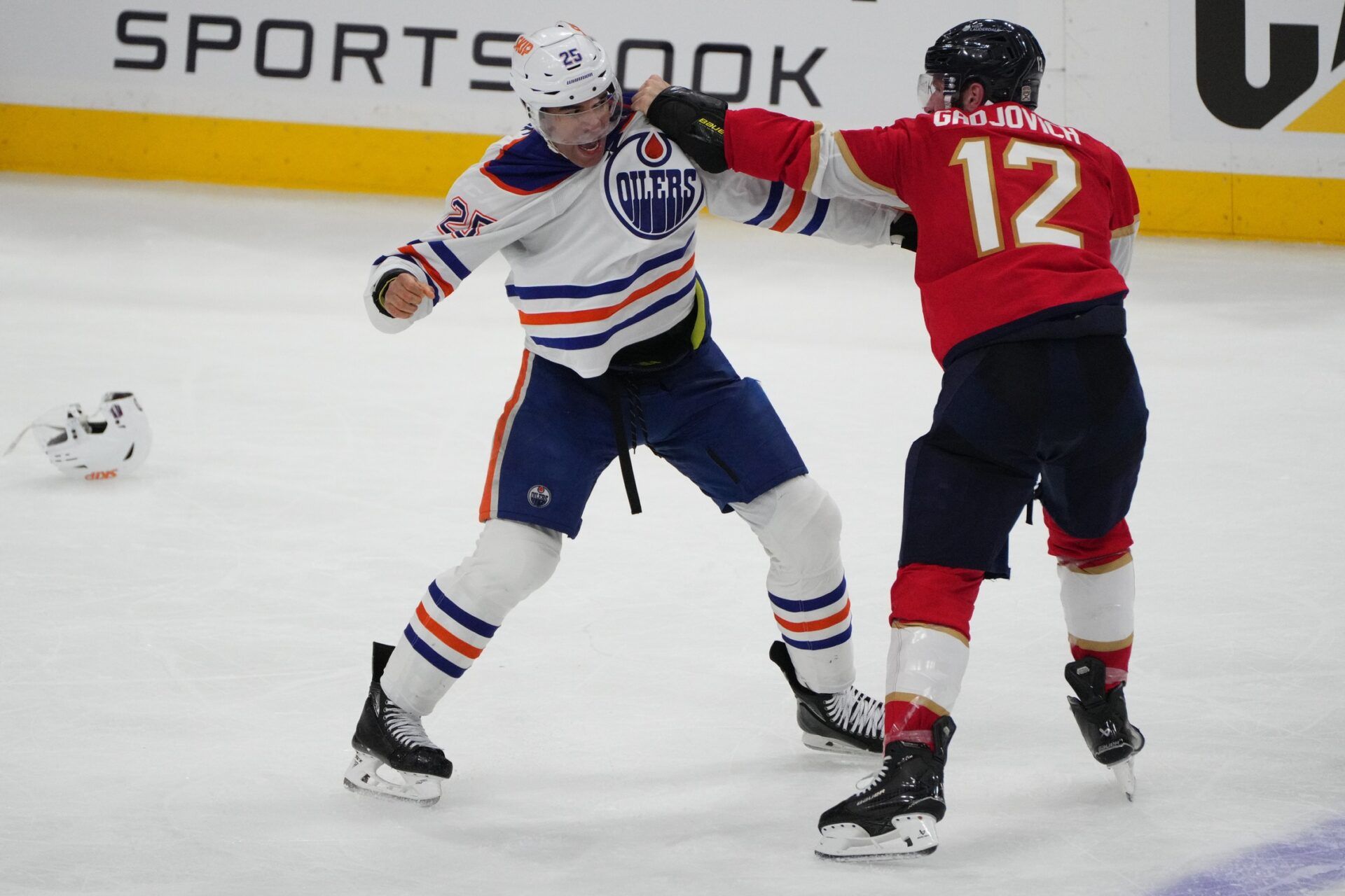 Florida Panthers forward Jonah Gadjovich (12) and Edmonton Oilers defenseman Darnell Nurse (25) fight during the third period in game three of the 2025 Stanley Cup Final at Amerant Bank Arena.