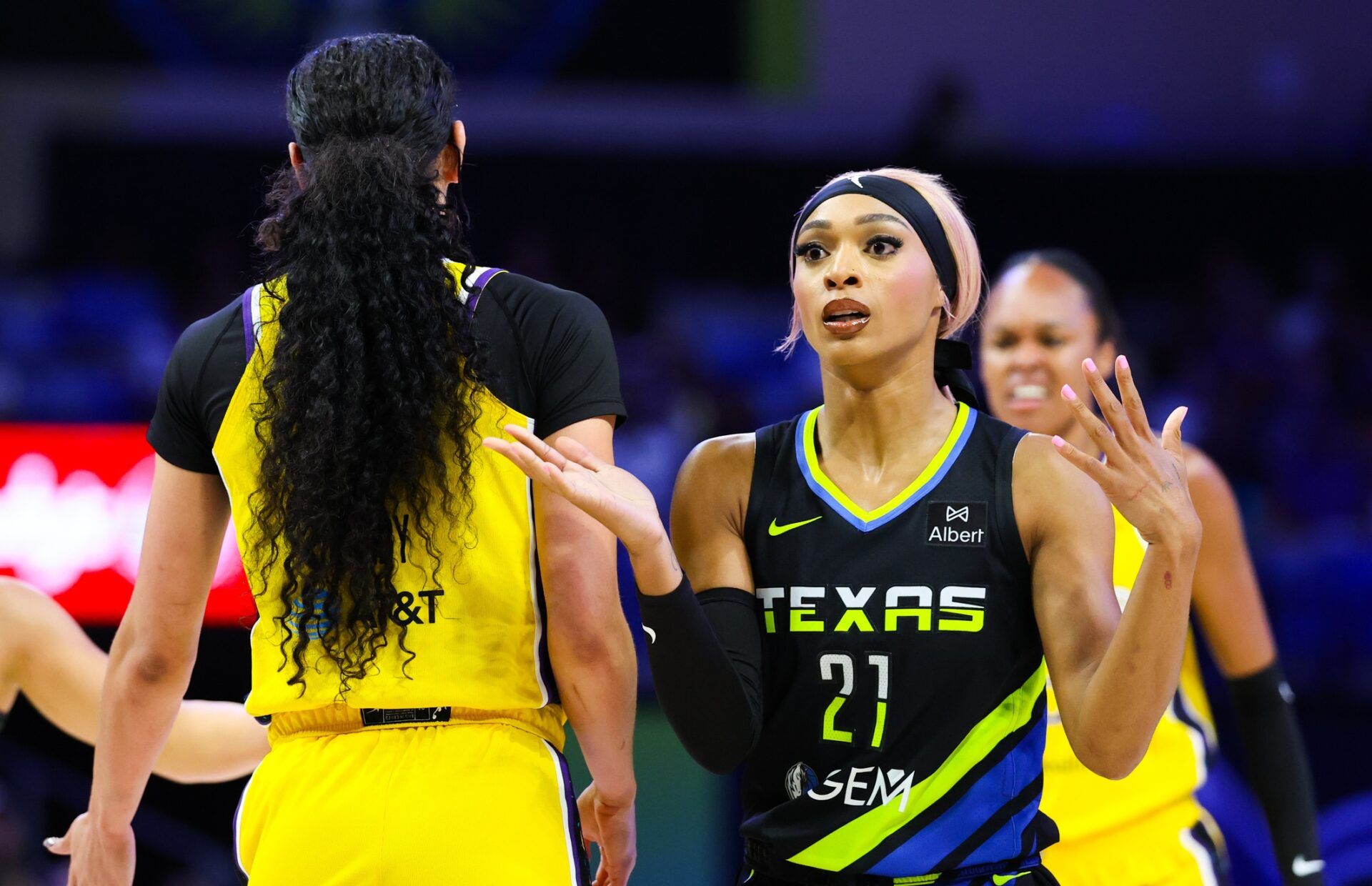 Dallas Wings guard DiJonai Carrington (21) reacts as Los Angeles Sparks forward Dearica Hamby (5) celebrates during the first half at College Park Center.