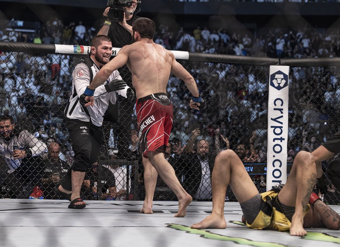 Islam Makhachev (blue gloves) defeats Charles Oliveira (red gloves) during UFC 280 at Etihad Arena.