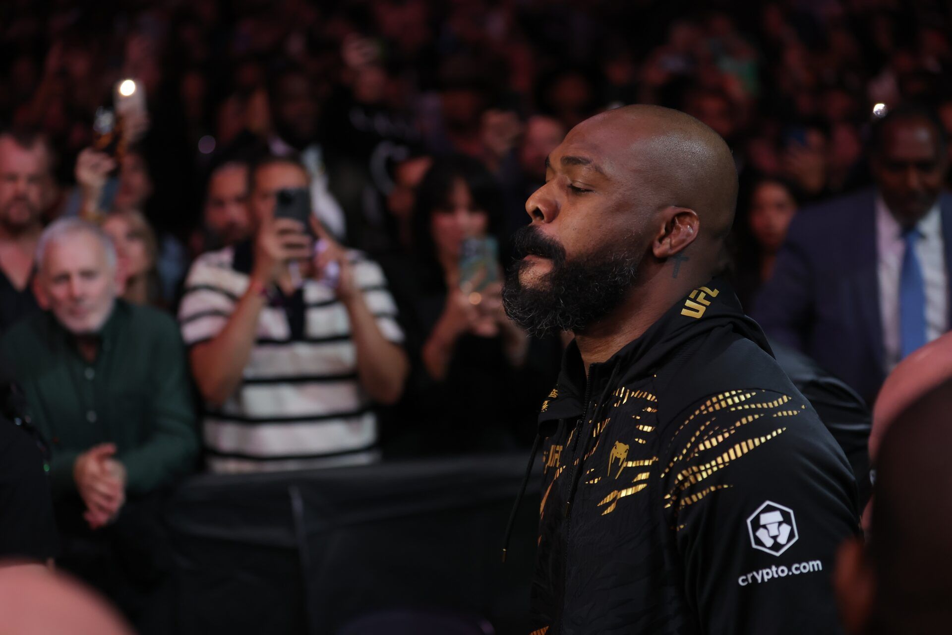 Jon Jones (red gloves) enters prior to fighting Stipe Miocoic (blue gloves) in the  heavyweight bout during UFC 309 at Madison Square Garden.