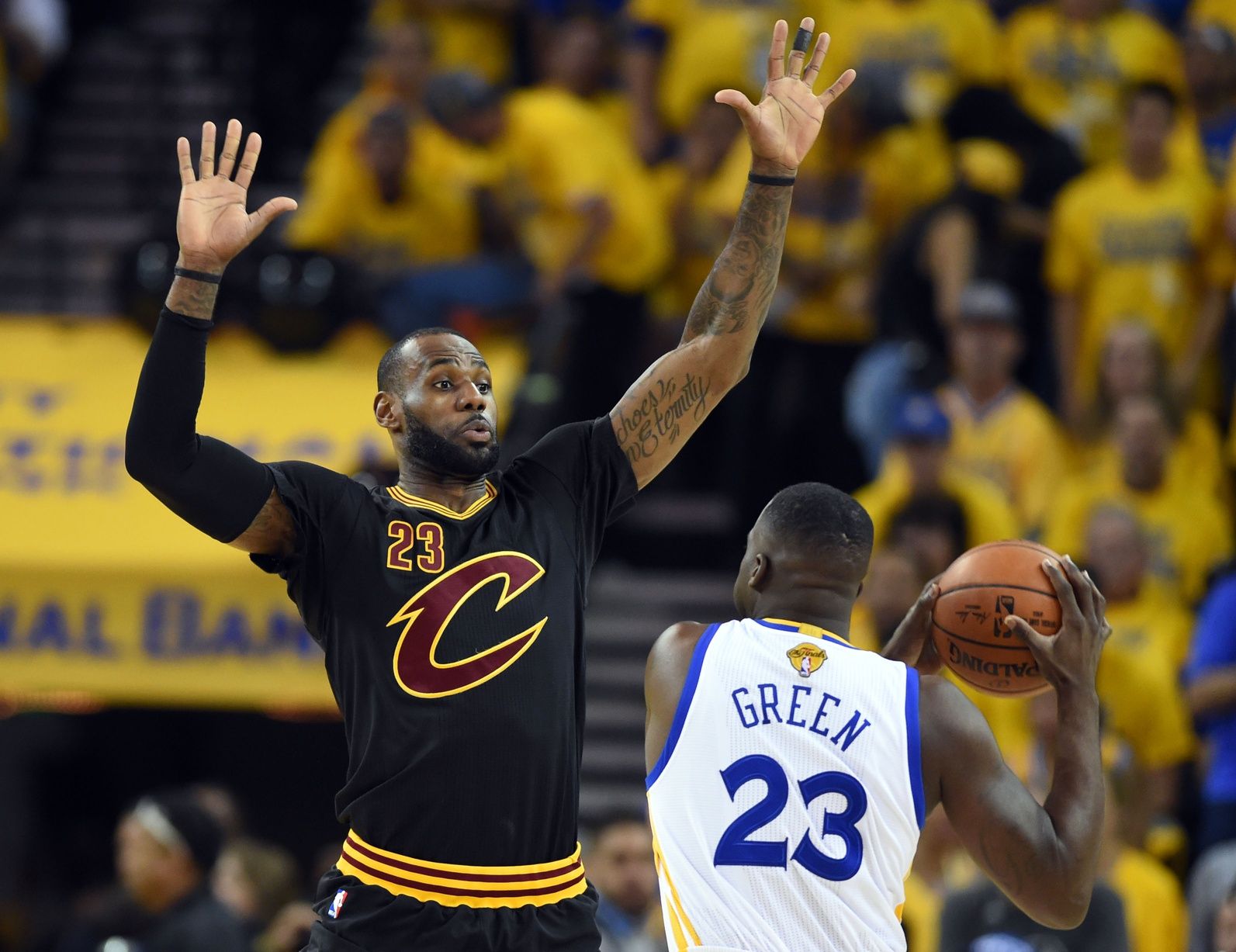 Golden State Warriors forward Draymond Green (23) handles the ball against Cleveland Cavaliers forward LeBron James (23) during the first quarter in game seven of the NBA Finals at Oracle Arena.