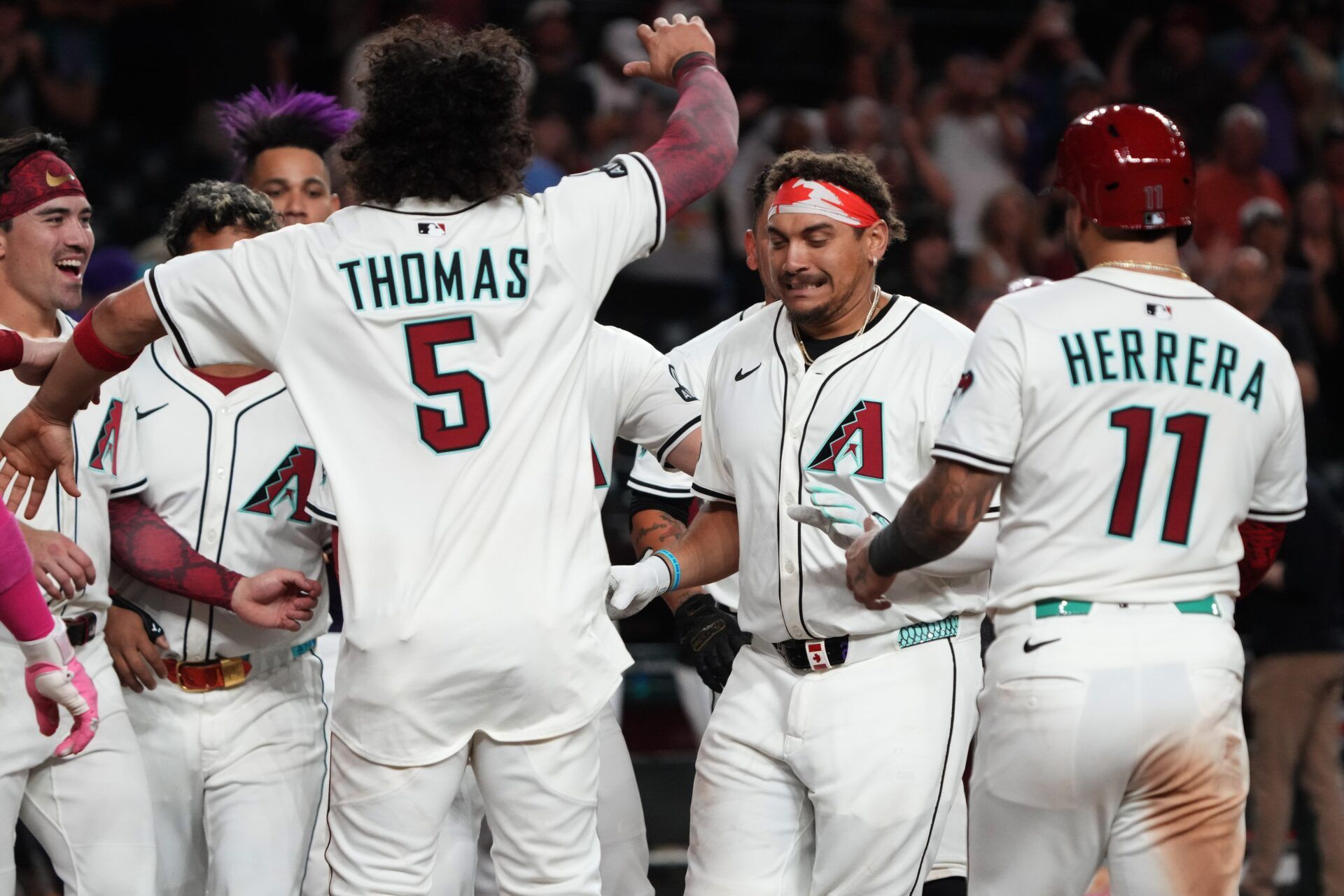 Arizona Diamondbacks first base Josh Naylor (22) celebrates with teammates after hitting a walk off grand slam home run against the Seattle Mariners in the eleventh inning at Chase Field.