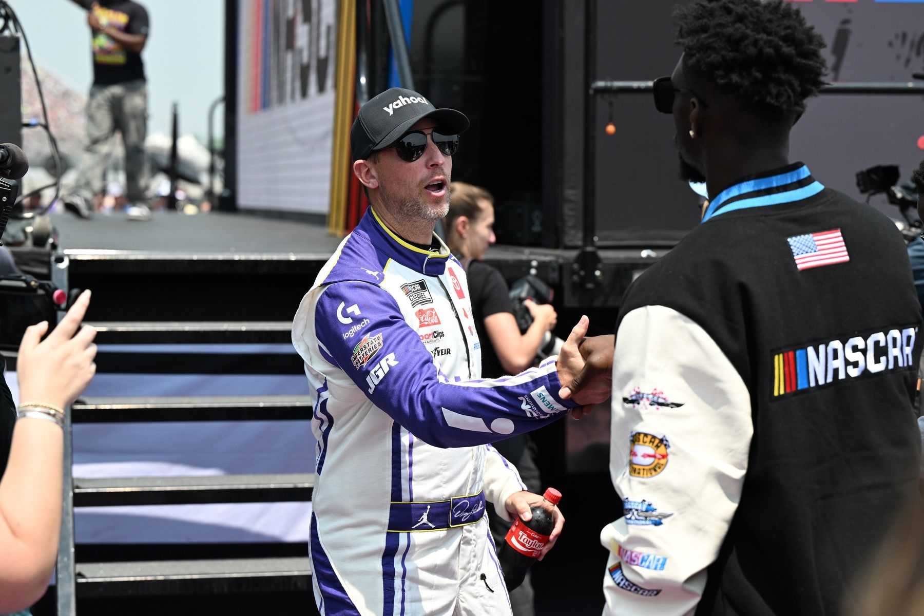 NASCAR Cup Series driver Denny Hamlin (11) greets Detroit Lions safety Kerby Joseph during driver introductions before the start of the FireKeepers Casino 400 at Michigan International Speedway.