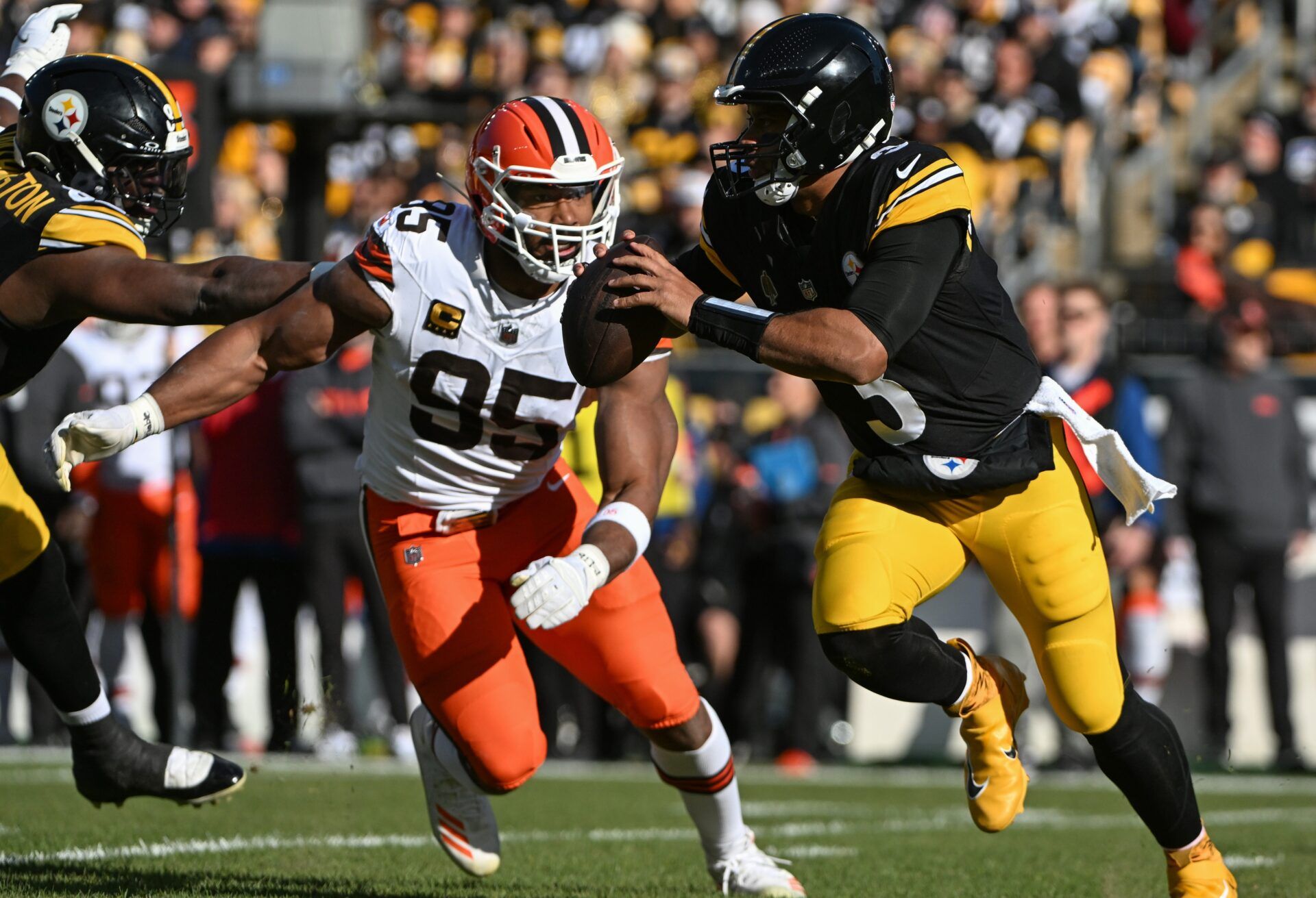 Pittsburgh Steelers quarterback Russell Wilson (3) is chased by Cleveland Browns defensive end Myles Garrett (95) during the first quarter at Acrisure Stadium.