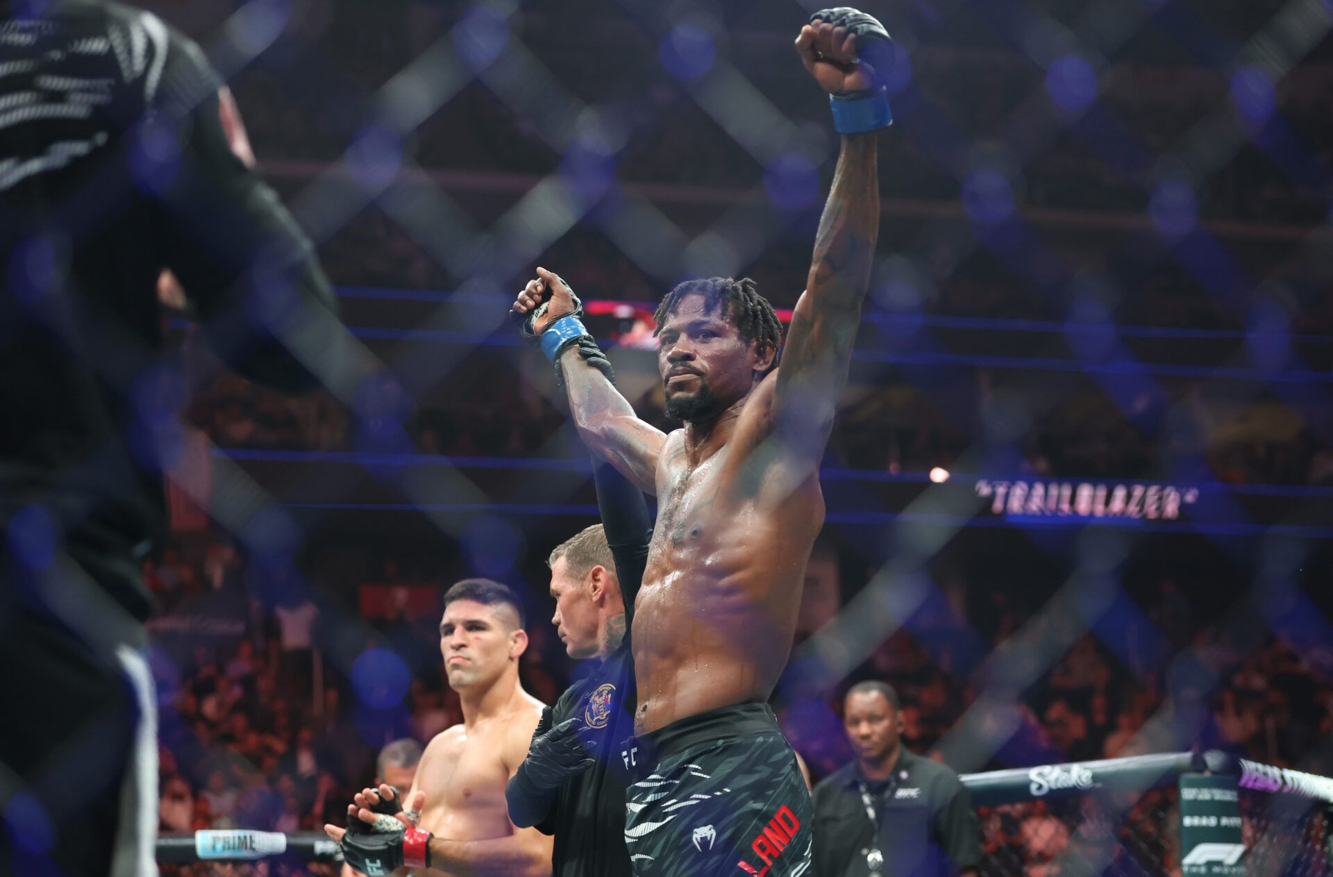 Kevin Holland (blue gloves) reacts after defeating Vicente Luque (red gloves) during UFC 316 at Prudential Center.