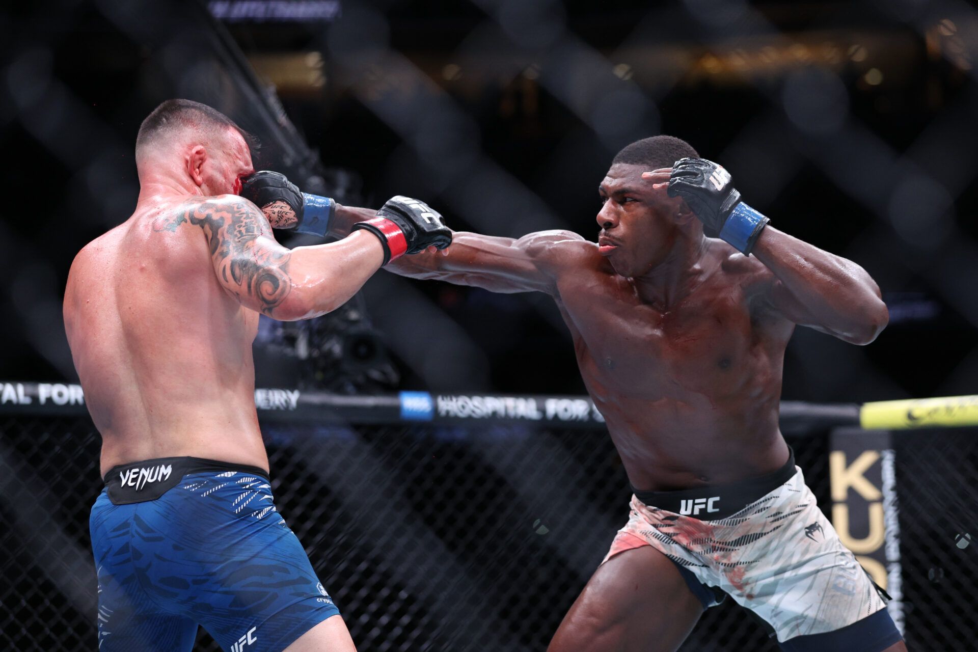 Colby Covington (red gloves) fights Joaquin Buckley (blue gloves) at Amalie Arena.