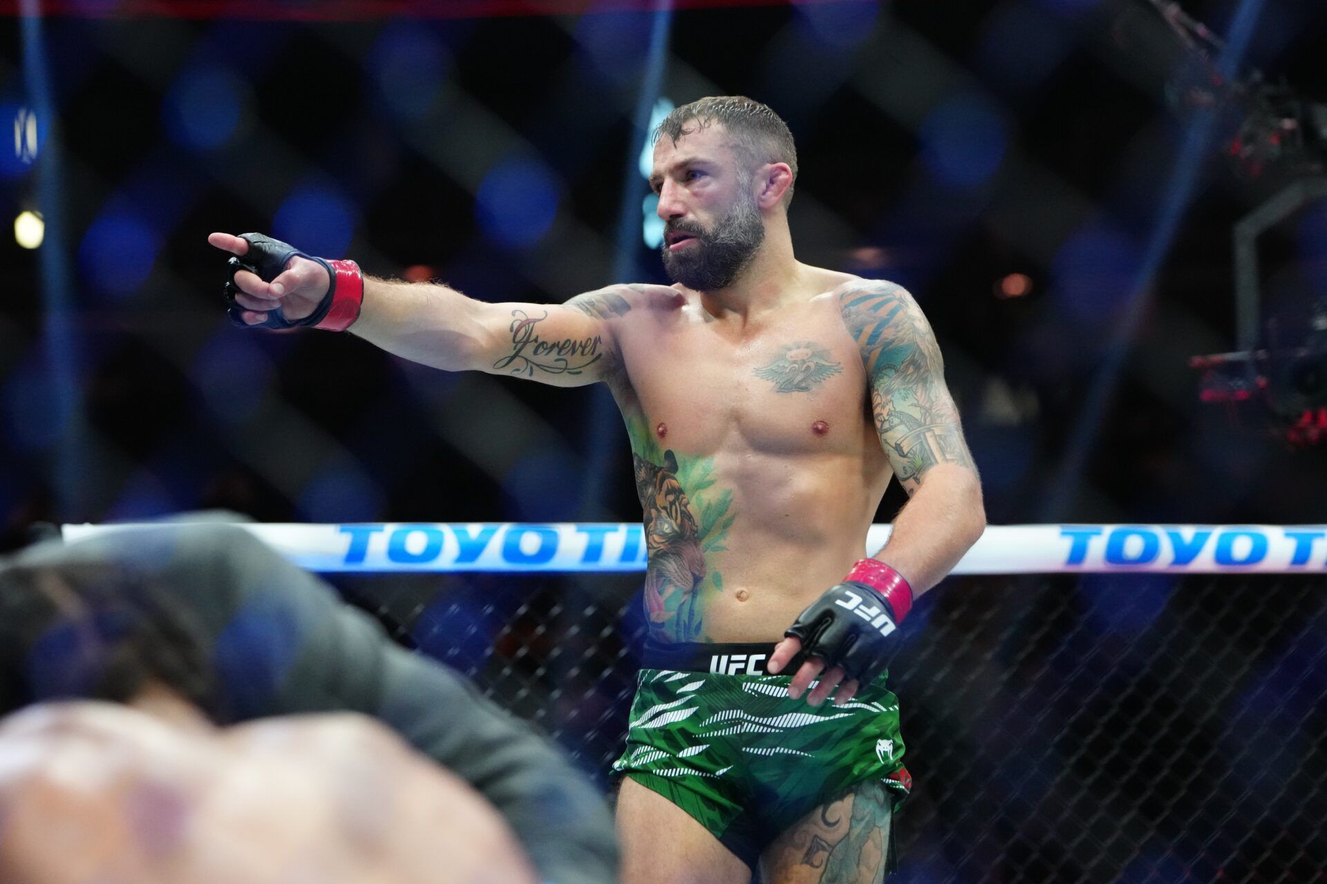 Michael Chiesa (red gloves) reacts after defeating Max Griffin (blue gloves) at T-Mobile Arena.