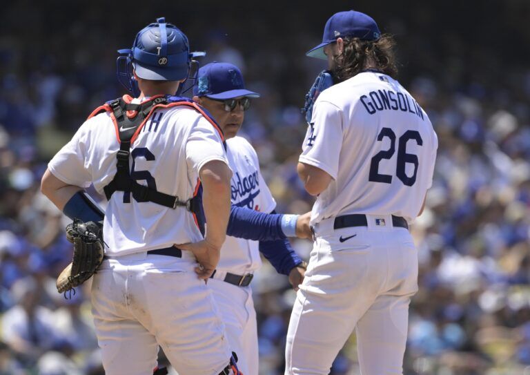 Los Angeles Dodgers manager Dave Roberts (30) pulls starting pitcher Tony Gonsolin (26) as catcher Will Smith (16) looks on in the sixth inning against the San Francisco Giants at Dodger Stadium.