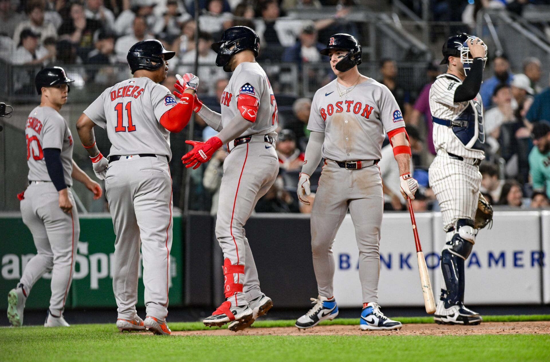 Boston Red Sox catcher Carlos Narváez (75) is greeted at home plate by designated hitter Rafael Devers (11) after hitting a three-run home run against the New York Yankees during the sixth inning at Yankee Stadium.