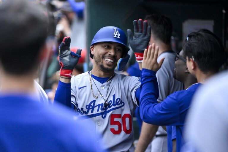 Los Angeles Dodgers shortstop Mookie Betts (50) is congratulated by teammates after hitting a solo home run against the St. Louis Cardinals during the seventh inning at Busch Stadium.