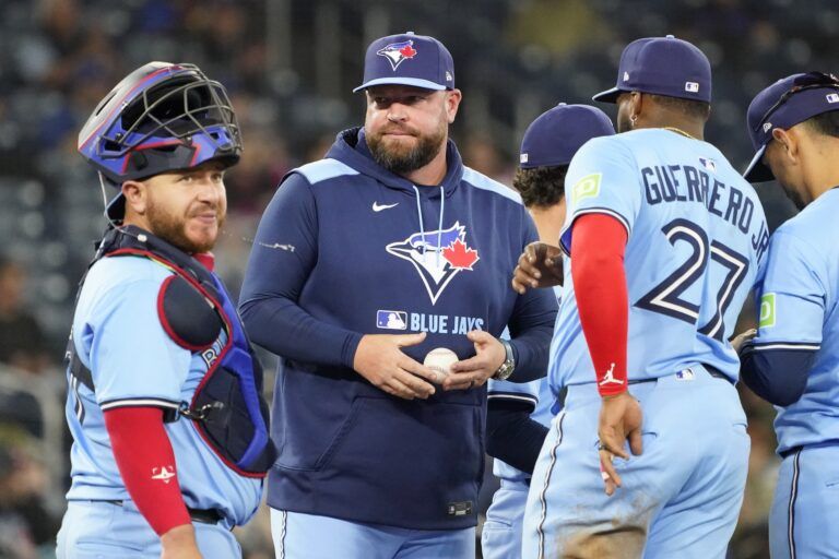 Toronto Blue Jays manager John Schneider (center) visits the pitching mound along with catcher Alejandro Kirk (30) during the eighth inning against the Washington Nationals at Rogers Centre.