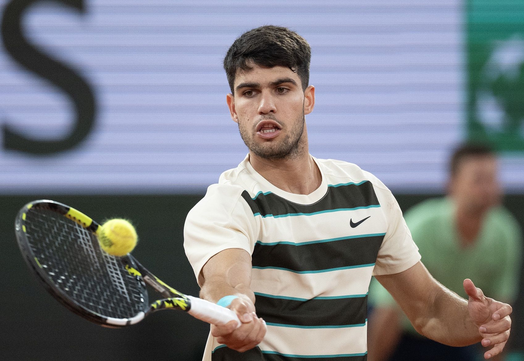 Carlos Alcaraz of Spain returns a shot during his match against Lorenzo Musetti of Italy match on day 13 at Roland Garros Stadium.