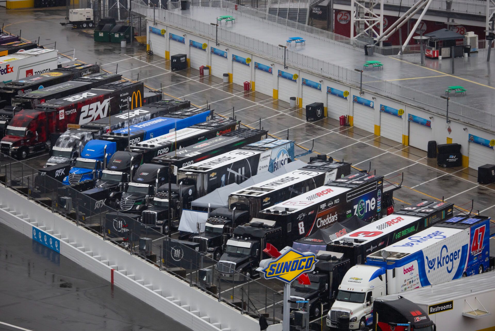 Overall view of NASCAR Cup Series car haulers in the empty garage area as it rains following the postponement of the Daytona 500 to Monday due to rain at Daytona International Speedway.