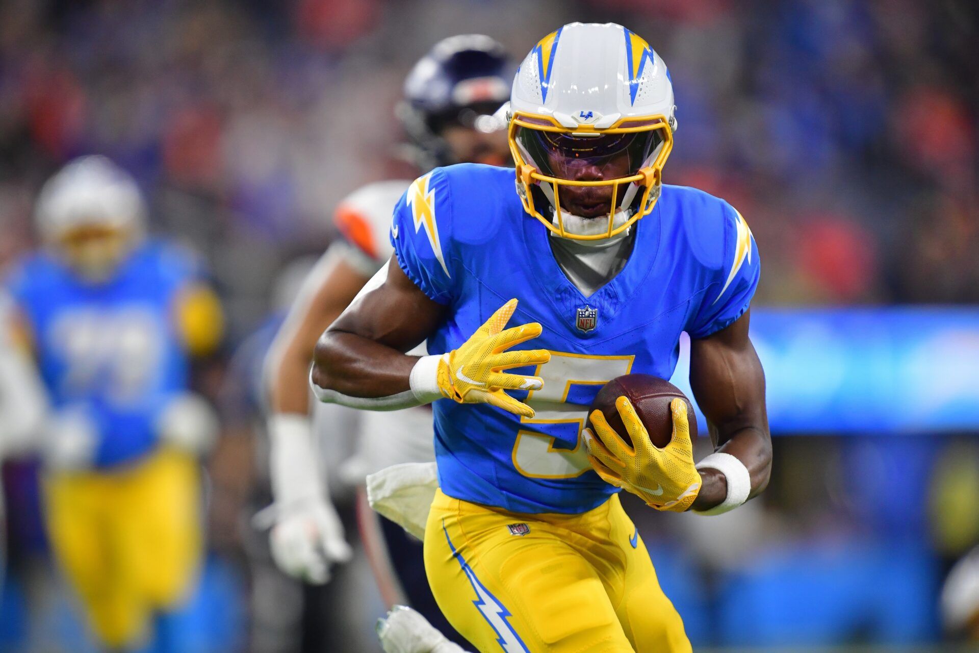Los Angeles Chargers wide receiver Joshua Palmer (5) runs the ball against the Denver Broncos during the first half at SoFi Stadium.
