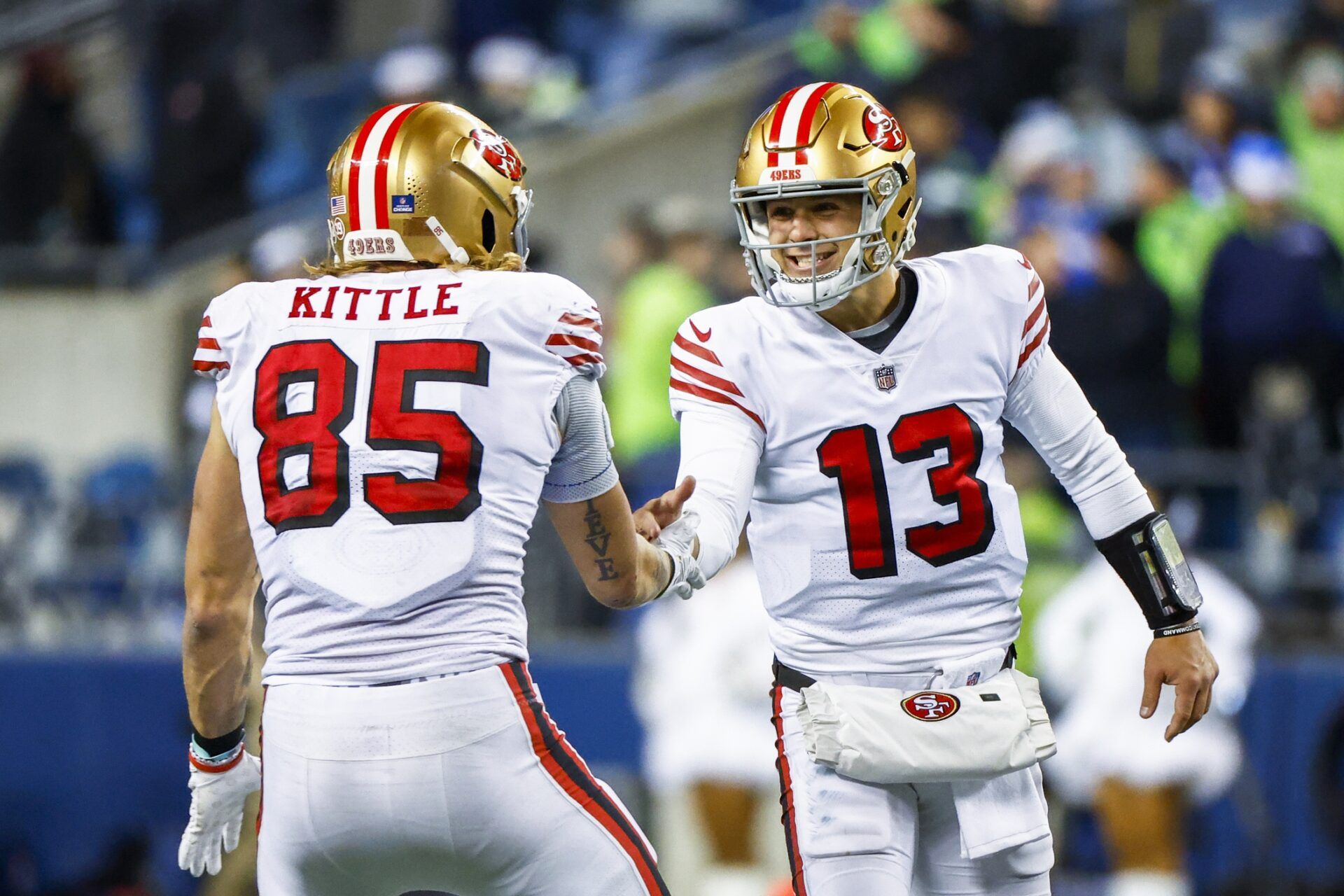 San Francisco 49ers quarterback Brock Purdy (13) celebrates with tight end George Kittle (85) during the late fourth quarter against the Seattle Seahawks at Lumen Field.