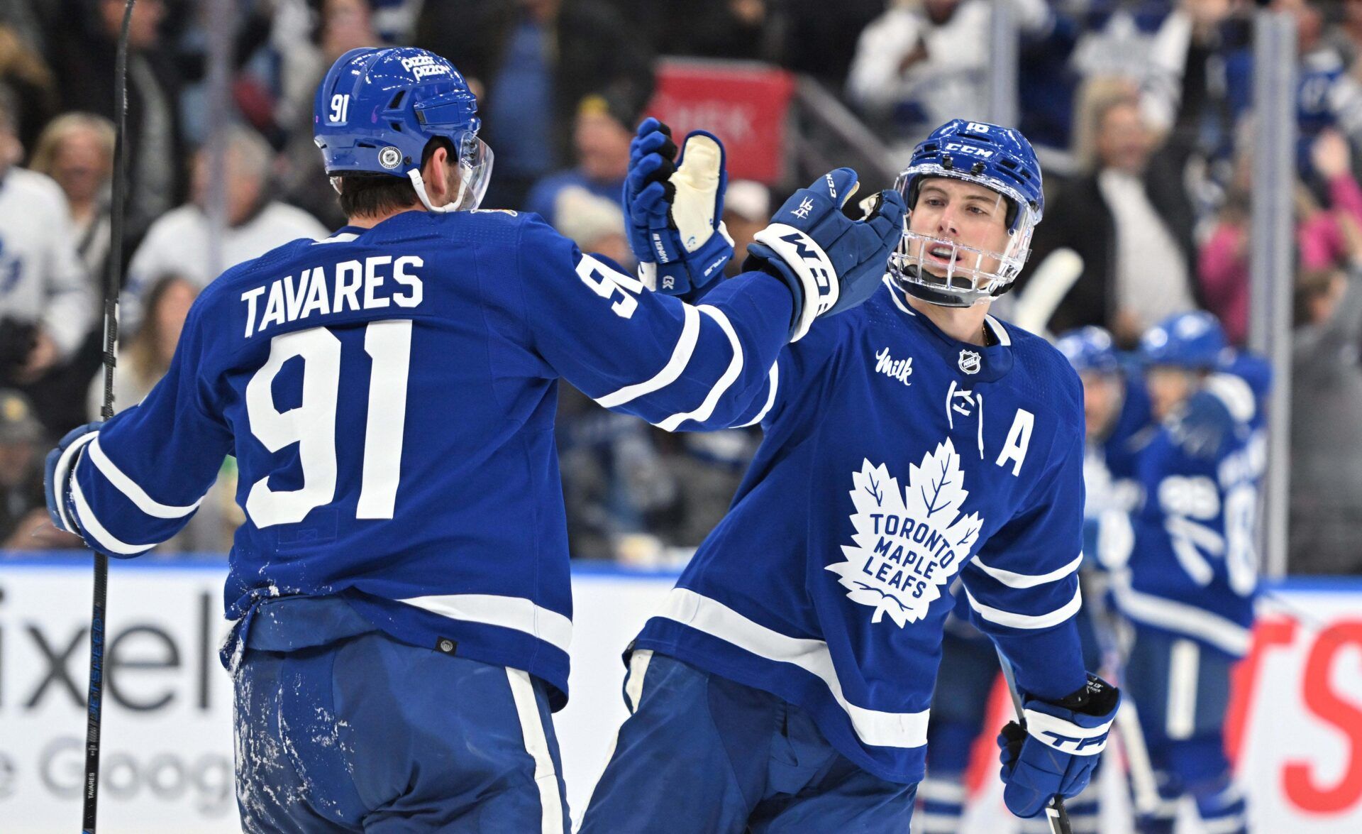 Toronto Maple Leafs forward Mitchell Marner (16) slaps hands with forward John Tavares (91) after a goal against the Boston Bruins in the third period at Scotiabank Arena.