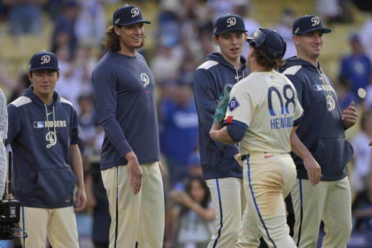 Los Angeles Dodgers first baseman Kiki Hernandez (8), pitched the ninth inning, is congratulated by starting pitchers Yoshinobu Yamamoto (18), left, Tyler Glasnow and Roki Sasaki after defeating the New York Yankees at Dodger Stadium.
