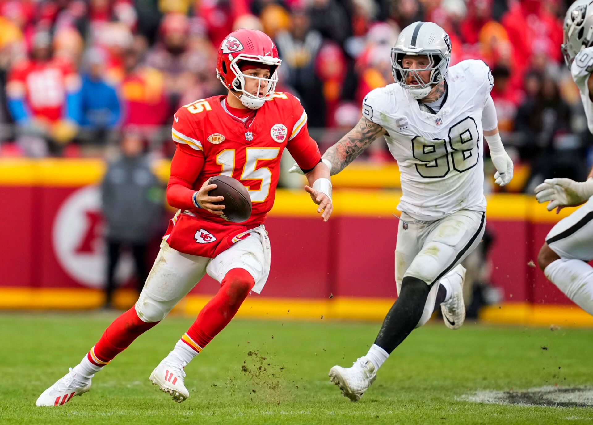 Kansas City Chiefs quarterback Patrick Mahomes (15) scrambles against Las Vegas Raiders defensive end Maxx Crosby (98) during the second half at GEHA Field at Arrowhead Stadium.