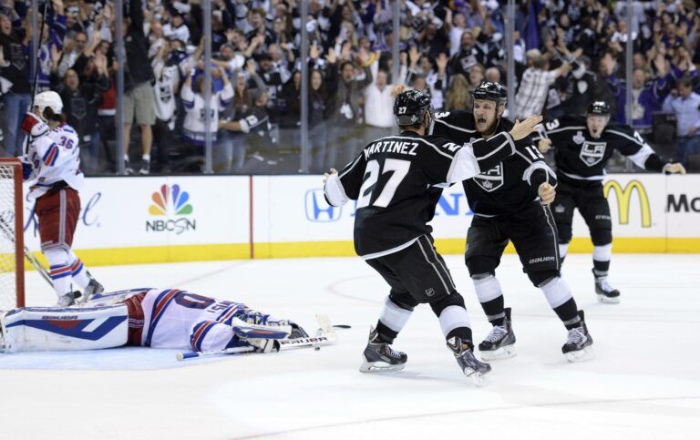 Los Angeles Kings defenseman Alec Martinez (27) celebrates with teammates after scoring the game-winning goal against the New York Rangers during the second overtime period in game five of the 2014 Stanley Cup Final at Staples Center.