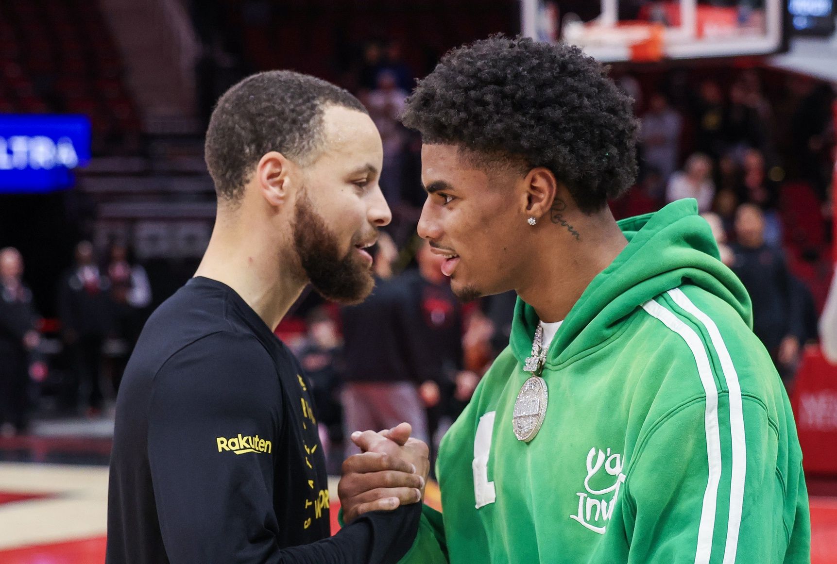 Golden State Warriors guard Stephen Curry (30) shakes hands with Buffalo Bills wide receiver Keon Coleman before a game against the Houston Rockets at Toyota Center.