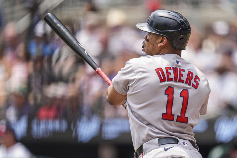 Boston Red Sox designated hitter Rafael Devers (11) follows through after hitting a double against the Atlanta Braves during the first inning at Truist Park.