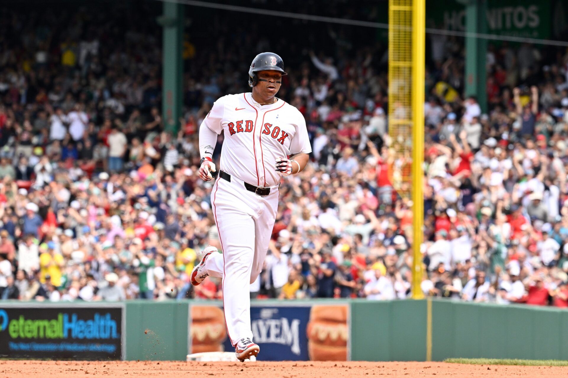 Boston Red Sox designated hitter Rafael Devers (11) runs the bases after hitting a one run home run against the New York Yankees during the fifth inning at Fenway Park.